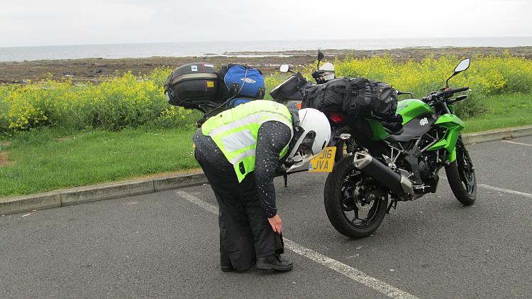 Sharon's zipper up her waterproof pants in a car park on the Ayrshire coast