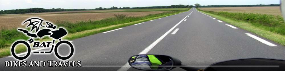 Looking along a long straight road amidst lush green farmland