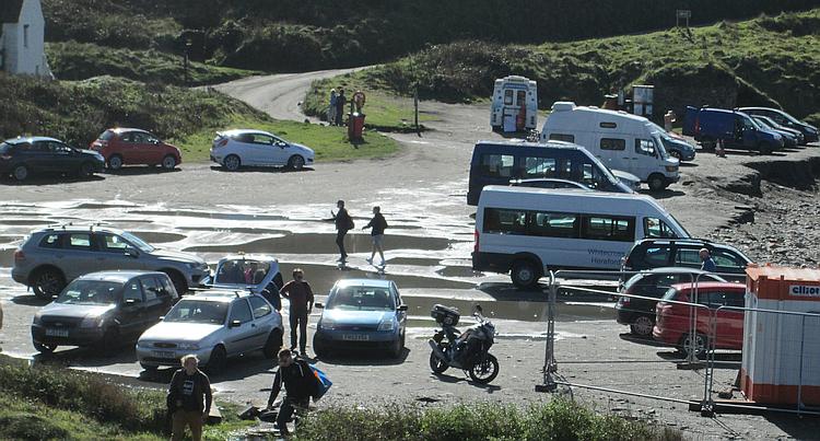 The car park at the beach is more like a deeply puddled patch of gravel with a few cars around
