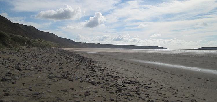 The beach stretches out for miles with hills rolling down at the edges