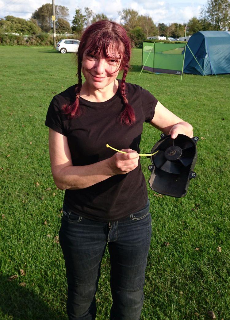 Sharon is smiling holding the fan which is not turning freely