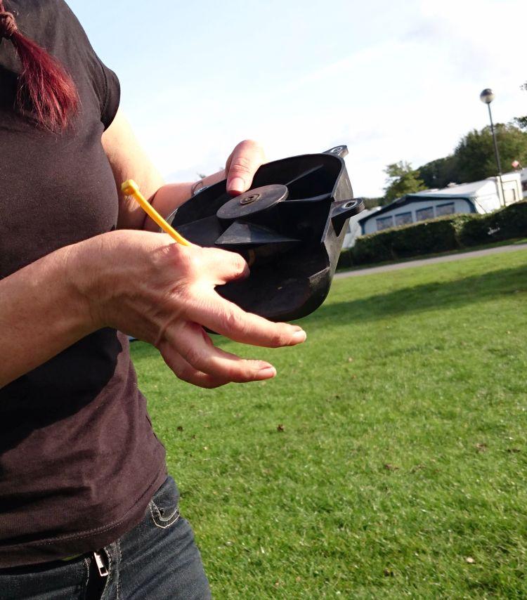 Sharon is poking a cable tie into the fan parts in an effort to dislodge the dirt