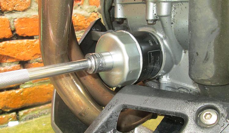 The oil filter removal tool covers the end of the old filter and helps get it undone