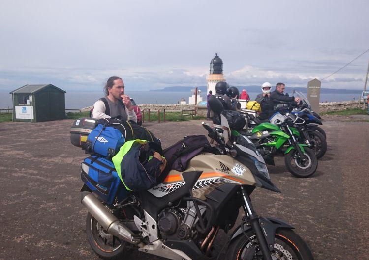Ren stands by his Honda CB500X at Dunnet Head. Ren's bike is sandy beige coloured