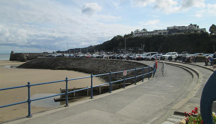 The beach and promenade at Saudersfoot with light fluffy clouds and blue skies