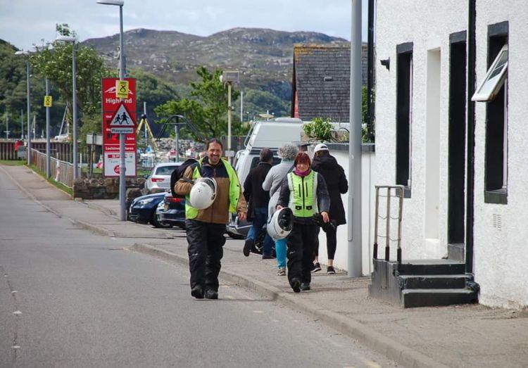 Sharon and Ren are walking through Lochinver in all their bike gear