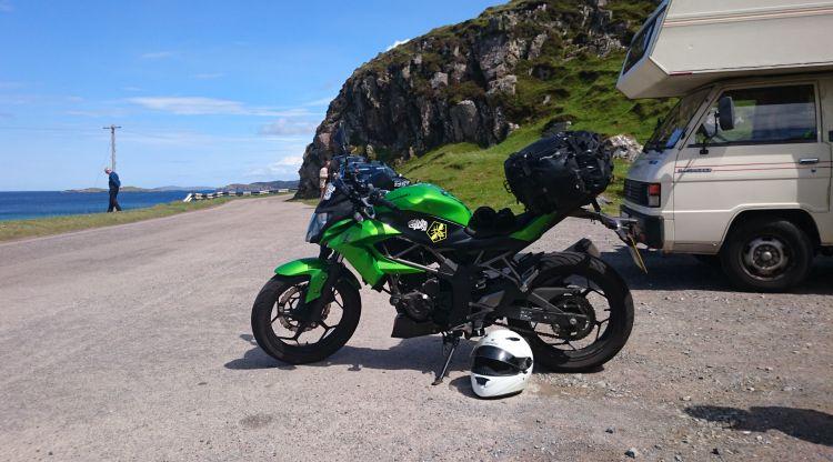 Sharon's green Kawasaki 250 set against the blue skies and views at Clashmessie