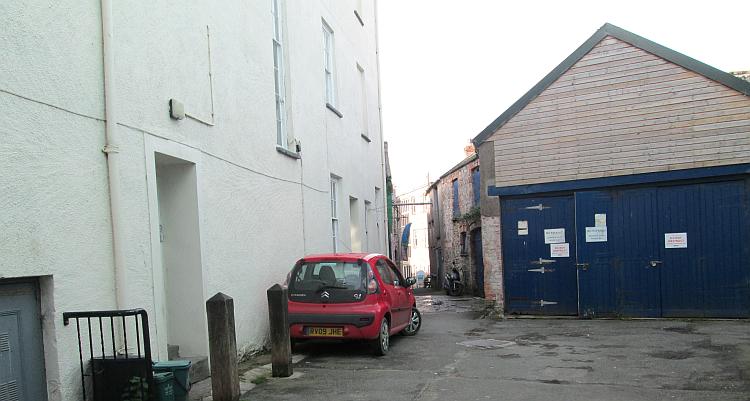 a car, a big lock up, odd shaped houses and a courtyard