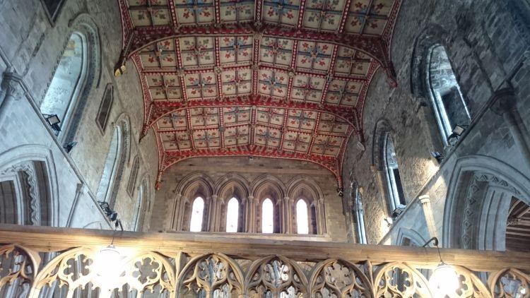 A colourful ceiling with reds and creams and woodwork and masonry