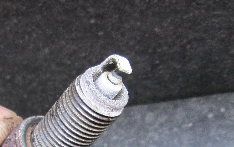 The tip of the old plug is has fine white deposits upon it, indicating it's running a little too hot