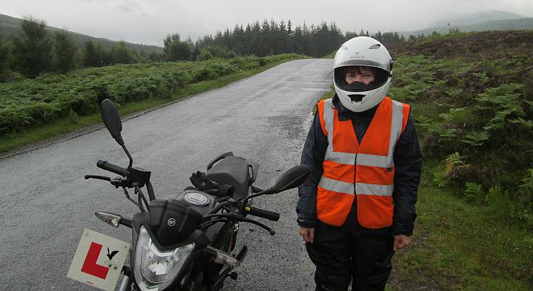 Sharon when she was a learner next to her bike with "L" plates in the rain