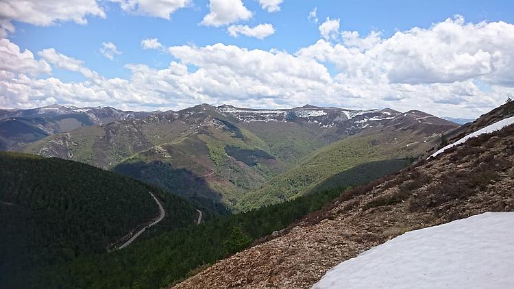 Looking out over the vast mountain range with snow capped peaks and green valleys
