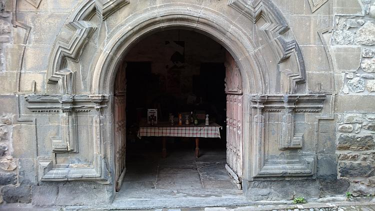 An ornate and detailed carved stone doorway and hefty wooden door in Potes