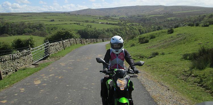 Sharon sits on her bike in the countryside on a warm sunny day
