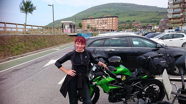 Sharon stands by her motorcycle posing in the Spanish sun looking relaxed