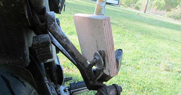 A piece of wood covers the sharp metal of the rear footrest