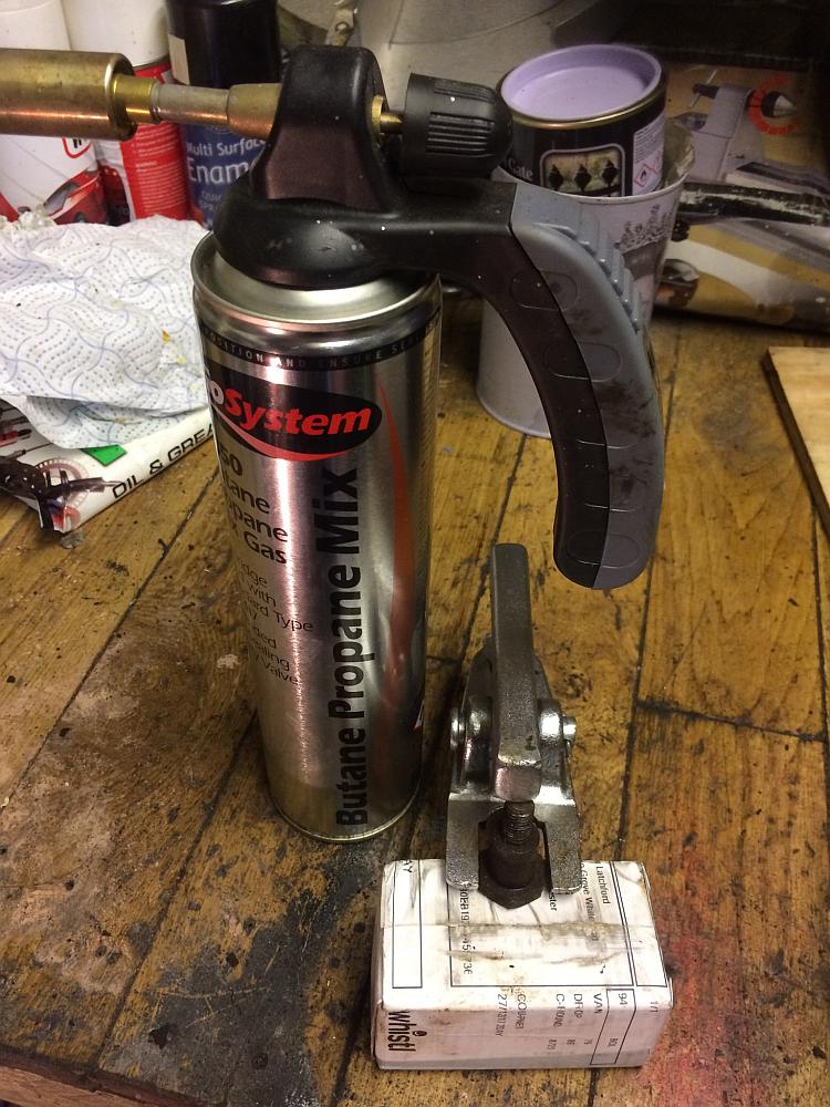 A propane blow torch next to the ball joint splitter and a very rusty bolt