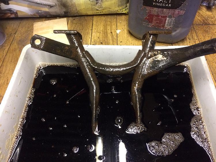 The centre stand in a tray of malt vinegar that has turned black from the corrosion