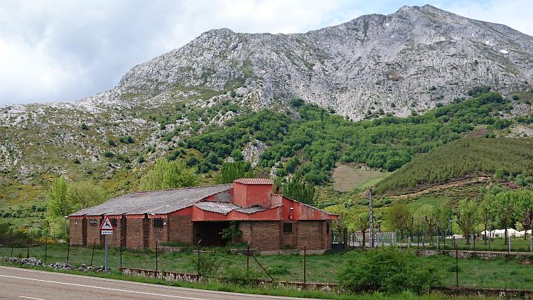 Large hills made mostly of white rocks with some greenery to be seen from the road in Spain