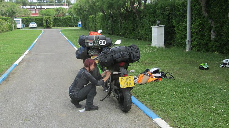 Sharon is strapping things to the Z250SL at Cabo Mayor campsite on a dull day