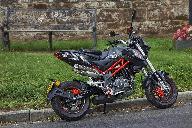 The Benelli looks very stylish and sharp set against an old stone wall and grass