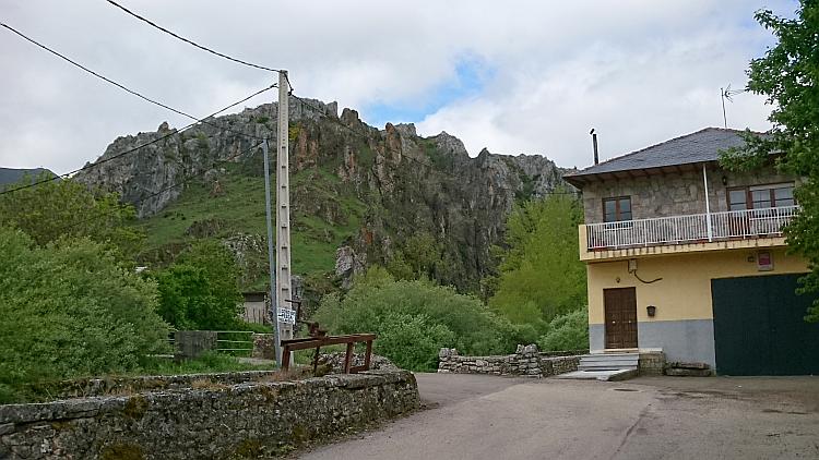 Rocky outcrops atop a hill behind a handful of houses along the CL626