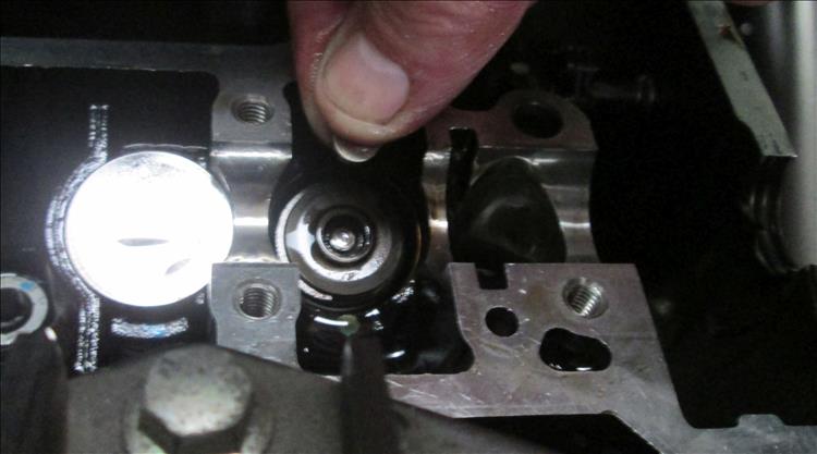Here the shim has just been removed from the top of the valve