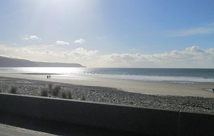 Blue skies with just a handful of fluffy clouds over the broad Barmouth beach