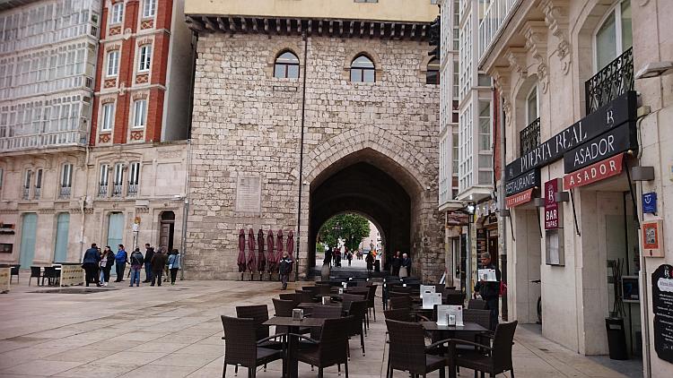 Old buildings with arches, cafe chairs and tables in the largs open square