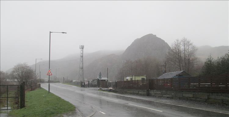 A very very wet road and hillside on a terrible and wet day