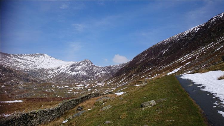 Rugged rocky mountain tops with snow, blue skies and whispy clouds, amazing scenery