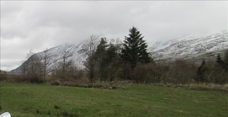Snow and rocks atop huge graggy mountains on the a5 in North Wales