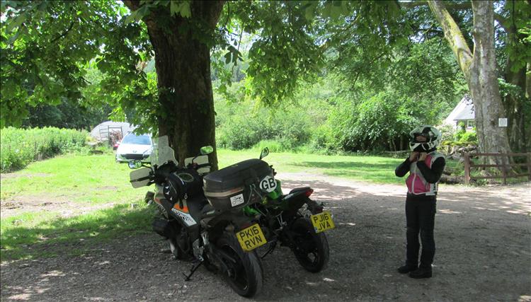 2 motorcycles among trees and sunshine near the cafe in the Beacons