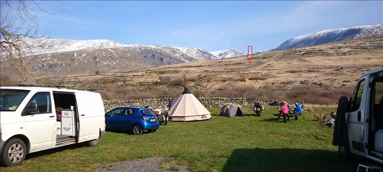 Welsh mountains with snow covered caps, an arrow points out the road we are to walk