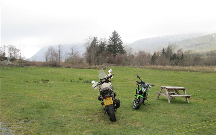 The 2 motorbikes set against misty grey skies in the morning at the campsite