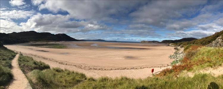A broad swathe of golden sand in a bay on the western coast