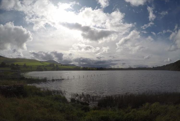 Looking out over the lakes are dark hills and cloudy skies at Overwater