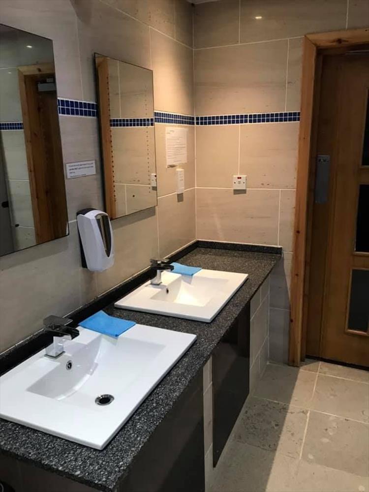 Smart sinks, mirrors and taps in clean tiled room at Port Ban