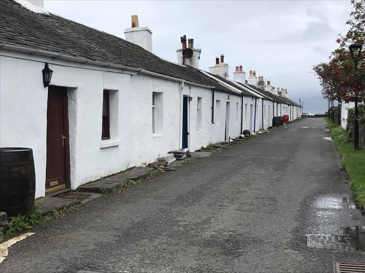 A row of small cottages painted white at the town of Ellenabeich