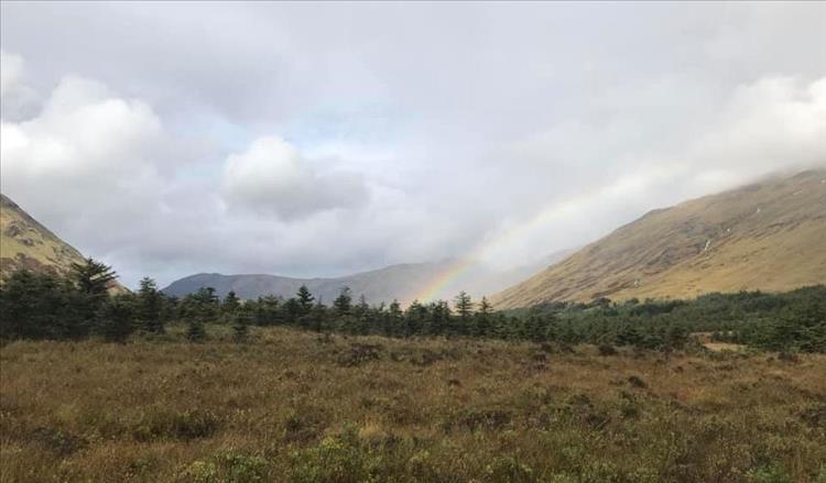 On the rugged moors and mountains of Scotland we can make out a rainbow disappearing into a valley