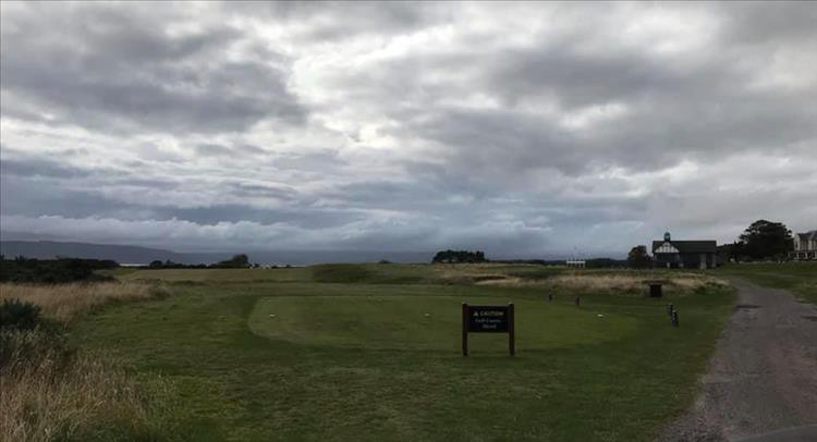 A simple gravel road runs by the golf course and club house