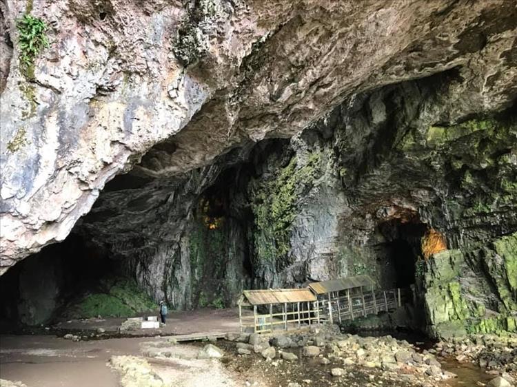 Looking into the cave it is rocky, craggy and rough with just a small wooden walkway