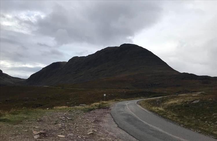 A large bulbous hill and a narrow lane at the start of the pass of the cattle