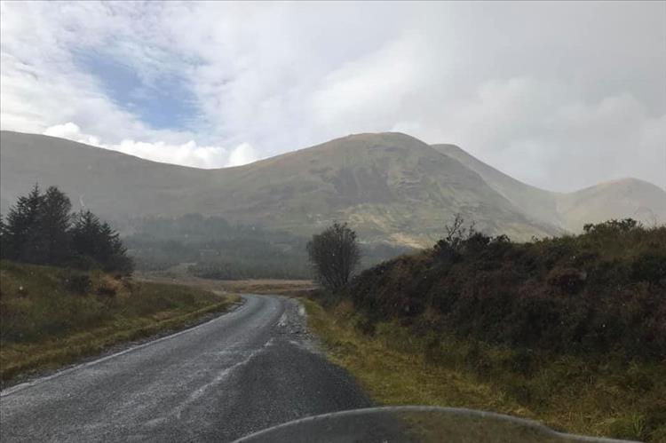 Round fat mountains and hills in changeable weather riding through The Highlands