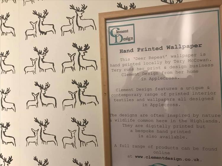 Simple hand printed wallpaper with a plaque describing who makes it and their details