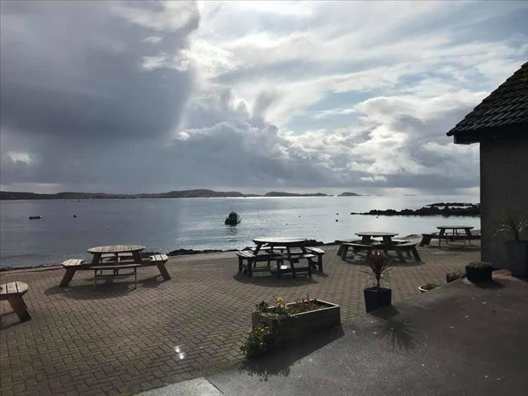 Looking across the calm waters with tables and chair from the cafe in the foreground