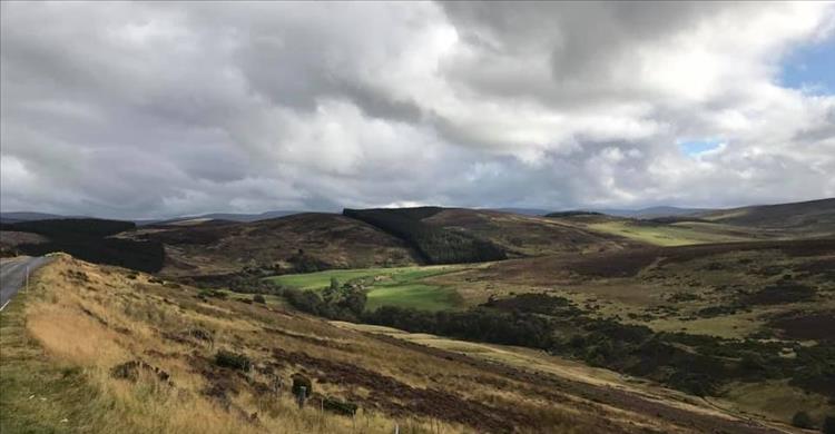 Grey skies yet gorgeous scenery as the road winds its way through vast rolling land