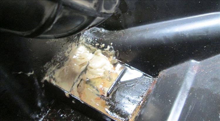 Under the cover is a bath of light brown or cream emulsified oil goo
