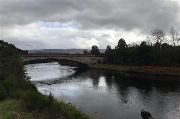 A stone bridge that is slim and slender crossing the river in one span