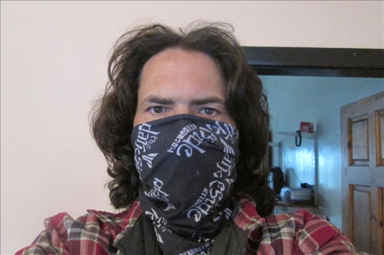 Ren has a motorcycle neck tube covering his face to reduce spread of covid 19
